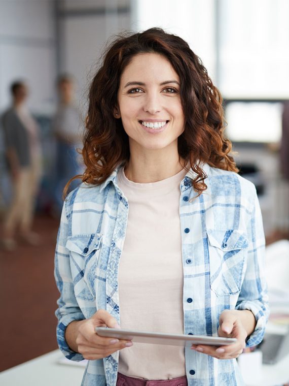 cheerful-young-woman-posing-in-creative-agency-P8NMKLX.jpg